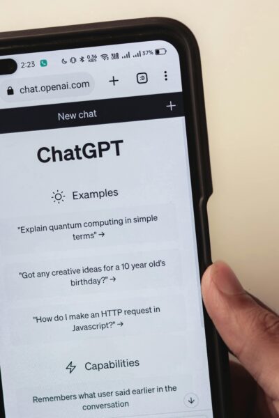Close-up of hands holding a smartphone displaying the ChatGPT application interface on the screen.